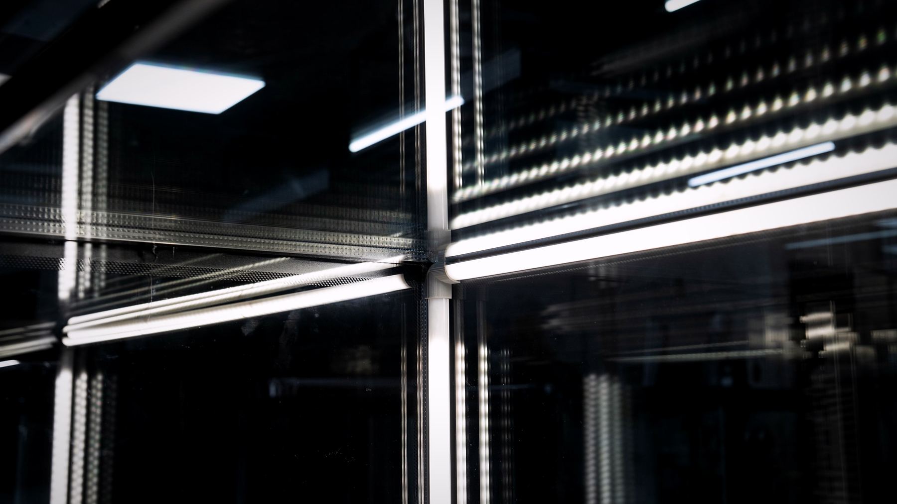 Tiras LED encendidas reflejadas en el vidrio de una vitrina refrigerada