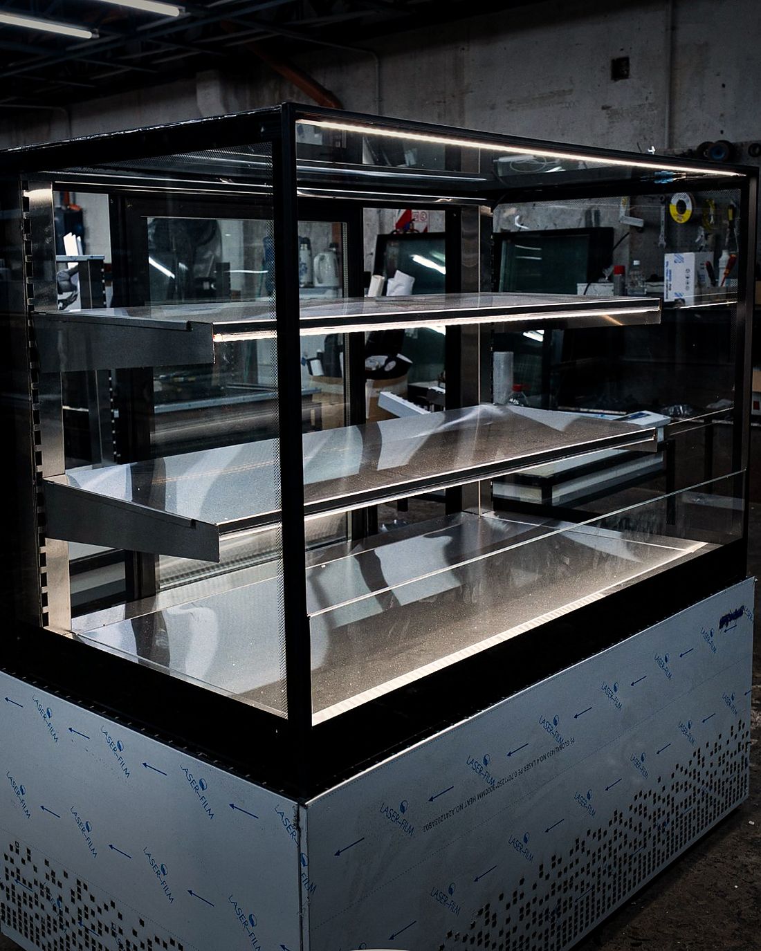 Vitrina con estantes en línea de armado, con luz LED bajo cada estante